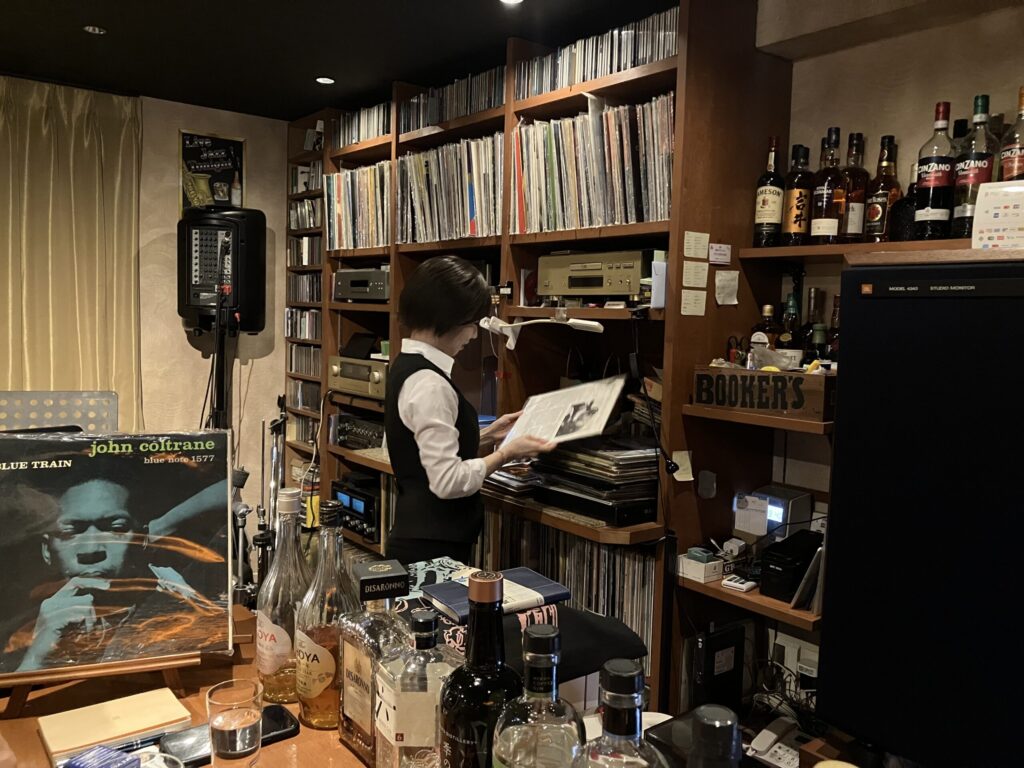 レコードを選ぶバーテンダーの女性