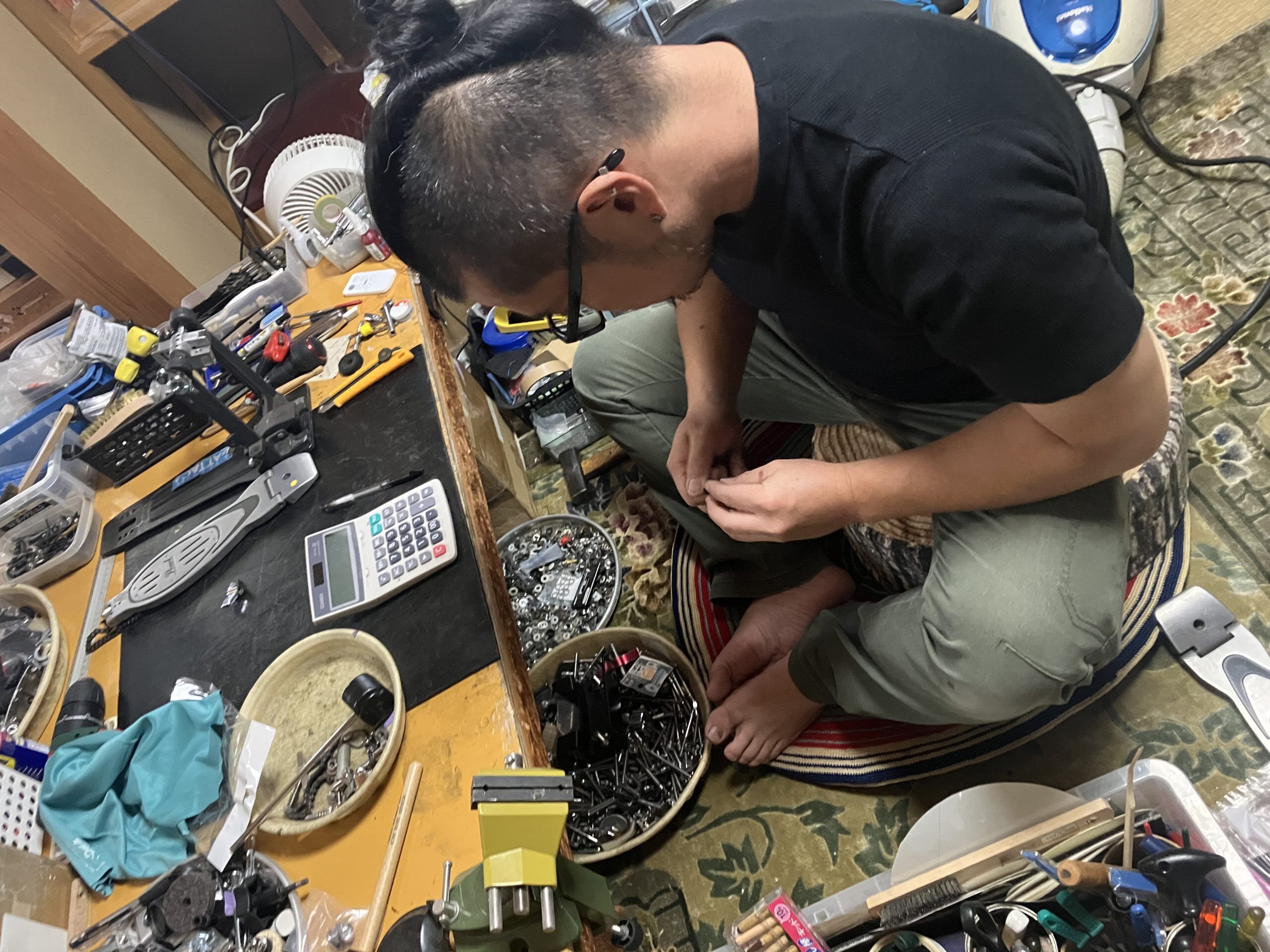 作業台前で作業をしている清水さん