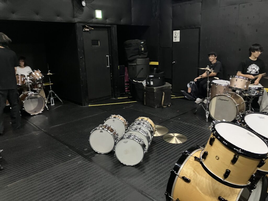 ドラマーとドラムセット。中央にスネアドラム。
