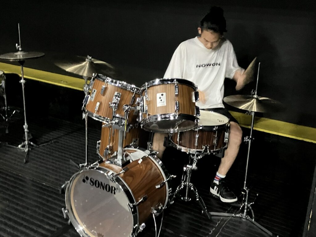 ドラムセットを叩く男子高校生