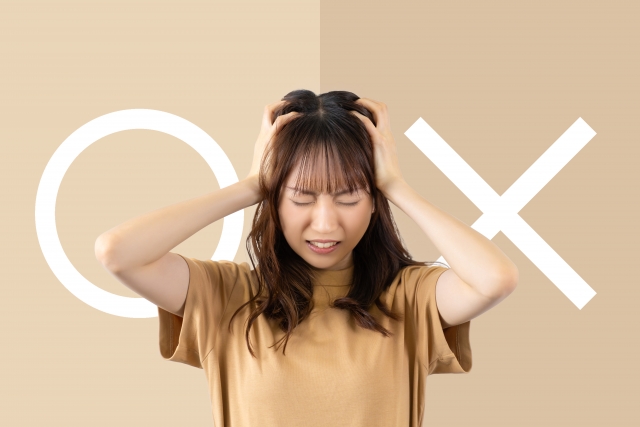 ◯か✗かを悩む女性